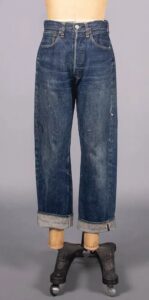 Pair of antique loose-fiitting cuffed blue jeans on a mannequin