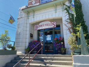 White storefront with a sign reading "Berry Fields" in red and stairs leading to glass front doors