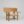 Wide chair in light wood with open arms and back; wide, flat crest rail; gold leaf joints; and upholstered seat