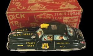 Green Dick Tracy toy car with lithographed windows in front of red box