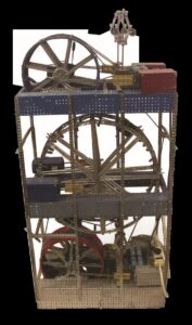 Metal electric toy display with 3 perforated levels and multiple Ferris-style wheels in red, blue, and silver