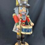Figural nutcracker as a drummer with a wooden hat, red uniform, and blue snare drum