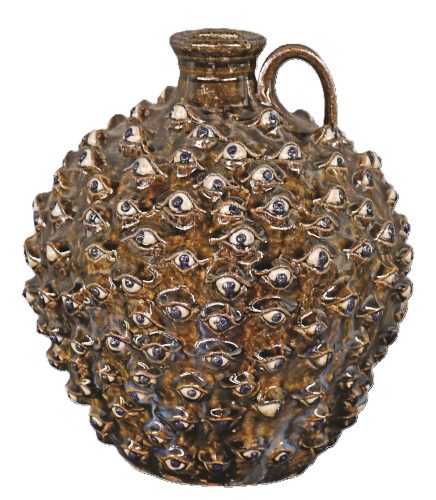 Round brown pottery jug with allover relief eyeballs